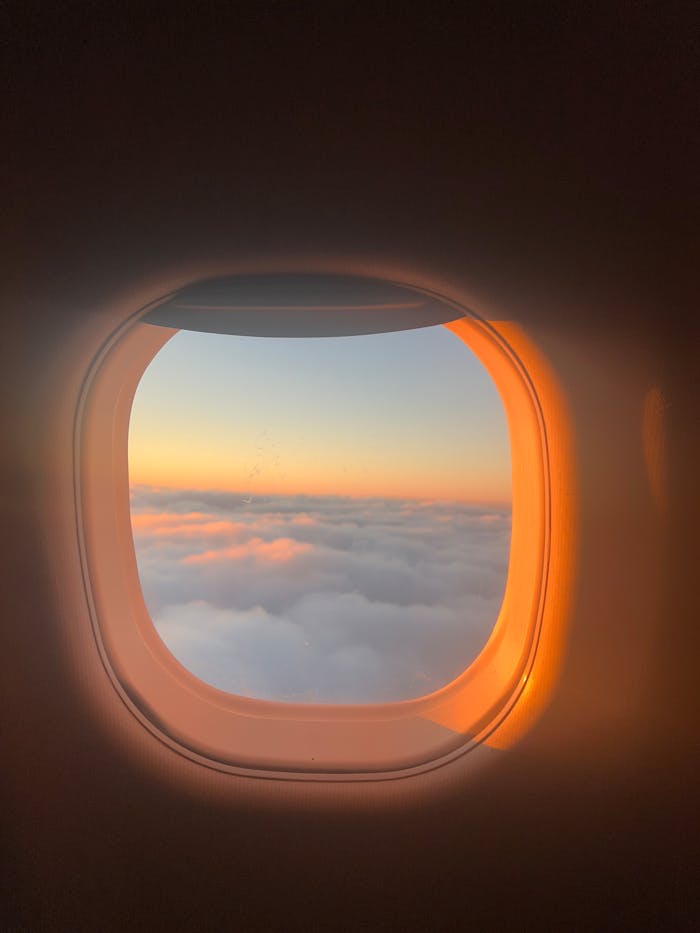 sunrise-view-from-airplane-window-over-clouds-30783827 sunrise-view-from-airplane-window-over-clouds-30783827